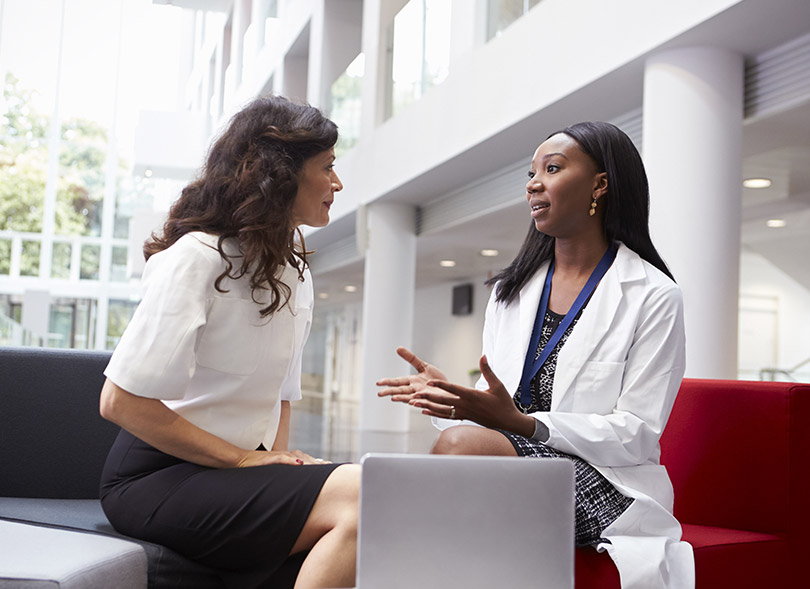 Female physician and financial department employee talking in lobby