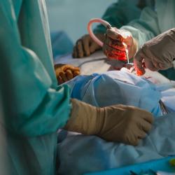 Patient in operating room with surgeons wearing gowns and gloves