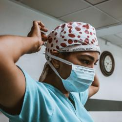 Surgeon wearing mask, scrubs, and surgical hat