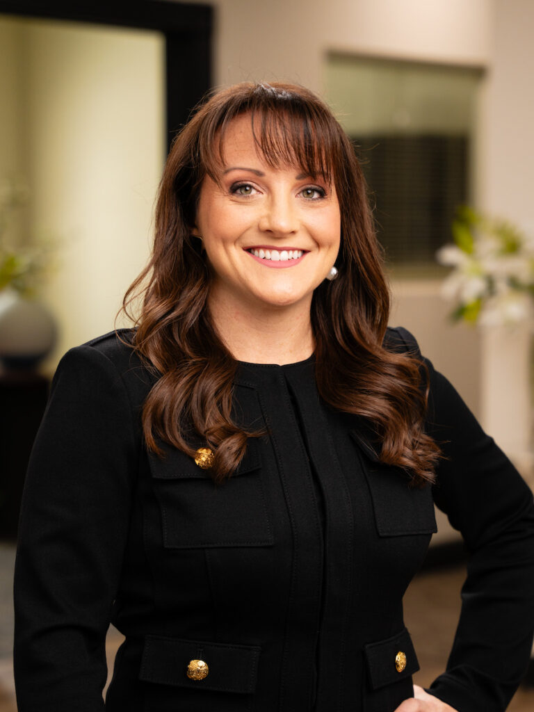 Net Revenue Employee, Brianna, posing for headshot wearing a black top, smiling