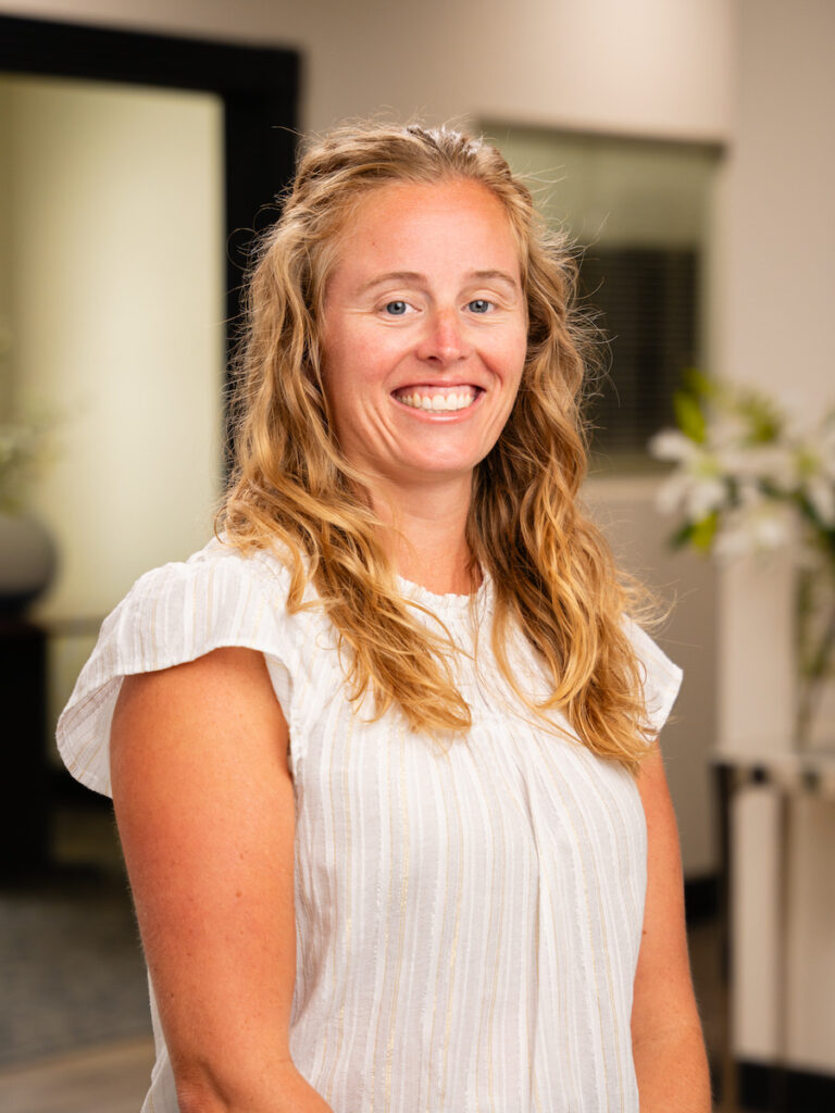 Net Revenue Employee, Gretchen, posing for headshot wearing white blouse and smiling